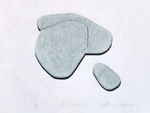 Woodcut printed with white ink on top of black ink in the shape of three stones, on white paper
