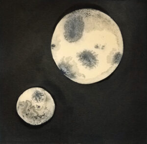 ink drawing of two moons on a black background