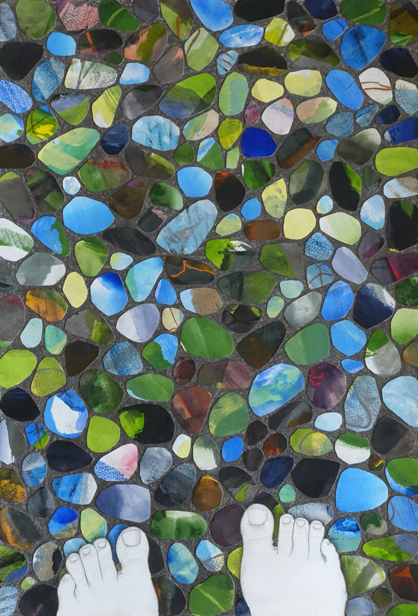 Graphite drawing from the artist's perspective. The artists feet are visible at the bottom of the image, standing on the ground. The ground is covered entirely with colorful, collaged rock-shaped objects.