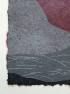 Detail of a woodcut print of an abstracted landscape with a moon above. The print is in shades of gray on purple paper.