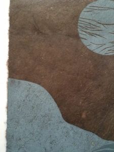 Detail of a woodcut print of an abstracted landscape with a moon above. The print is in shades of gray on brown paper.