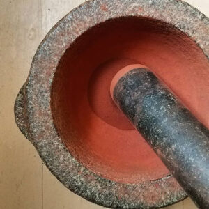 granite mortar and pestle grinding red Earth pigment