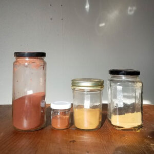 four jars of Earth pigment in shades of red and yellow